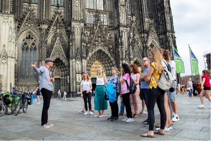 Tour guide giving explanations next to the Kölner Dom